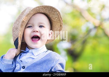 Portrait of a cute happy caucasian baby boy in spring park examine l'appareil photo Banque D'Images