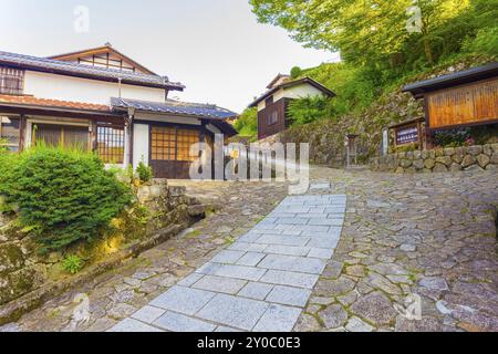 Des bâtiments en bois restaurés sur un chemin de pierre vallonné incliné mène à l'entrée de la ville de Magome sur l'ancienne partie Magome-Tsumago du sentier Nakasendo à Kiso V. Banque D'Images