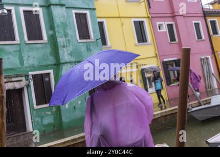 Vue sur la ville de Burano avec des maisons colorées et des canaux. Temps pluvieux, les gens portent des parapluies. Burano, Venise, Venise, Italie, Europe Banque D'Images