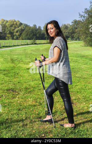 Jeune femme en randonnée avec des bâtons de marche nordique Banque D'Images