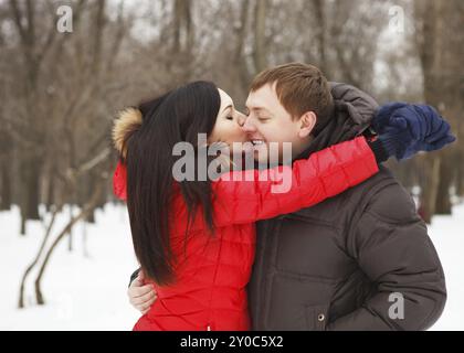 Happy young couple having fun in the winter park Banque D'Images