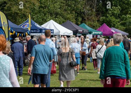 Les gens marchent autour d'une foire locale lors d'un jour férié ensoleillé en Angleterre. Août 2024. Banque D'Images