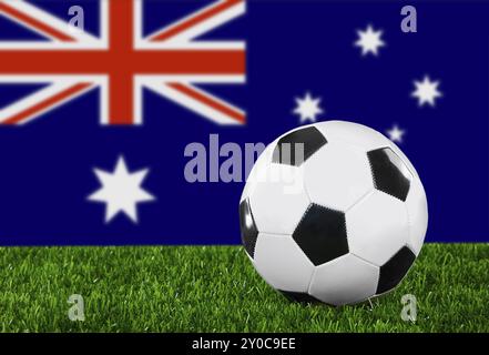 Le drapeau australien et le ballon de football sur l'herbe verte Banque D'Images