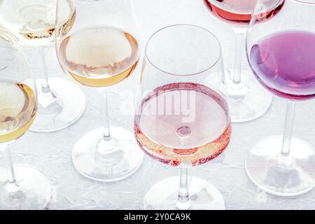 Verres à vin lors d'une dégustation. Vin rose, rouge et blanc, boissons sur une table dans une cave, image tonifiée. Un assortiment de vins de différentes couleurs, Fo Banque D'Images