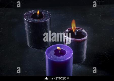 Bougies allumées sur un fond sombre, rituel mystérieux, photographie culinaire Banque D'Images