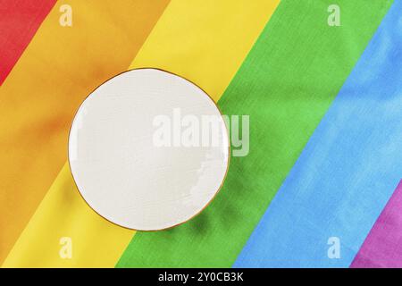 Concept de dîner gay. Une assiette, photographiée du haut sur la texture du drapeau arc-en-ciel LGBT, une pose à plat suspendue, photographie culinaire, photographie culinaire Banque D'Images