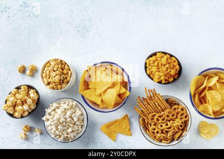 Snacks salés, mélange de fête, pris d'en haut avec un endroit pour le texte. Une variété de hors-d'œuvre sur un fond d'ardoise. Chips de pommes de terre et tortilla, craquelins, po Banque D'Images