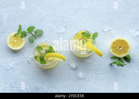 Limonade à la menthe. Boisson à l'eau de citron avec glace. Deux verres et citrons sur un fond pastel, plan d'eau au plafond avec espace de copie. Boisson détox. Banque D'Images