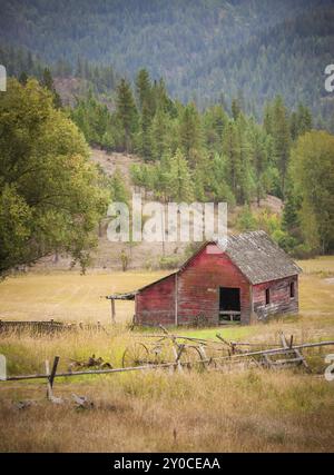 Une vieille grange rouge au milieu d'un pâturage ouvert à l'est de coeur d'Alene, Idaho Banque D'Images