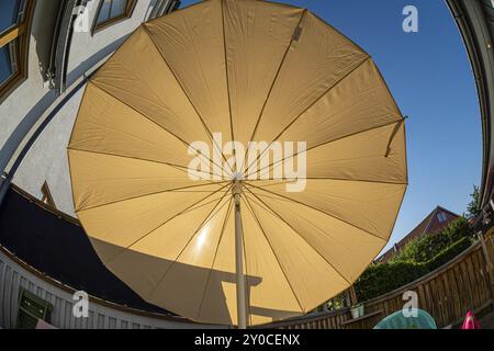 Soleil brillant à travers un grand parasol Banque D'Images