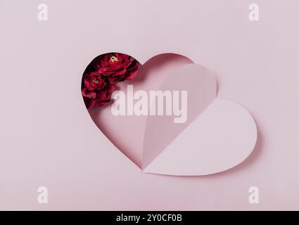 Message d'amour, mise en place conceptuelle de la Saint-Valentin. Vue de dessus sur papier incurvé, forme de coeur rose sur fond rose. Un minimum de mockup pour la Saint-Valentin Banque D'Images