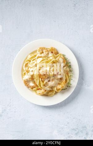 Pâtes de fruits de mer. Pappardelles aux crevettes et sauce crème dans une assiette blanche, avec thym frais, plan de dessus plat avec espace de copie Banque D'Images