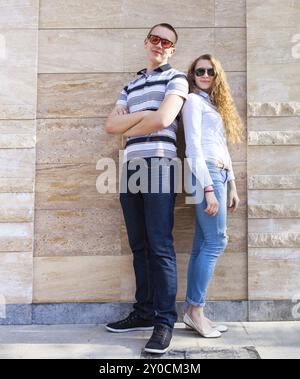 Jeune couple standing back to back portant des lunettes de soleil Banque D'Images