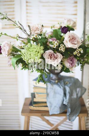 Bouquet élégant de fleurs roses et livres anciens. Décoration Vintage Banque D'Images