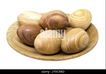 Oeufs en bois tournés à la main dans un petit bol en bois peint sur blanc Banque D'Images