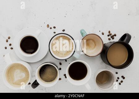 Vue de dessus sur un plat avec de nombreuses différentes compositions de tasses à café pleines et vides sur fond de béton blanc gris. Variété de tasse de thé collection vous Banque D'Images