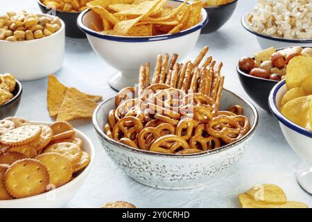 Collations salées, mélange de fête. Un assortiment de hors-d'œuvre croustillants dans des bols sur une table. Craquelins, bâtonnets, etc., photographie alimentaire Banque D'Images