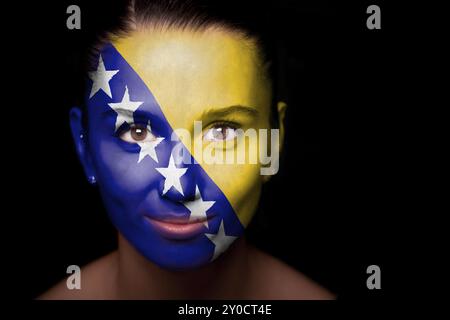 Portrait d'une femme avec le drapeau de la Bosnie-Herzégovine peint sur son visage Banque D'Images