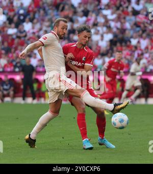 Munich, Allemagne. 1er septembre 2024. Harry Kane (G) du Bayern Munich affronte Max Rosenfelder de Fribourg lors du match de football de première division allemande de Bundesliga entre le Bayern Munich et le SC Freiburg à Munich, Allemagne, le 1er septembre 2024. Crédit : Philippe Ruiz/Xinhua/Alamy Live News Banque D'Images