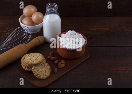 Les cookies d'avoine fait maison et les ingrédients pour la cuisson sur planche de bois rustique Banque D'Images