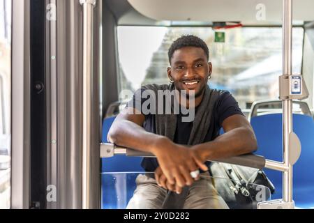 Portrait d'un homme africain heureux assis dans le bus public sur le chemin du travail Banque D'Images