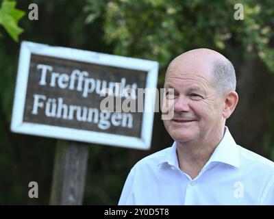Seelow, Allemagne. 29 août 2024. Le chancelier fédéral Olaf Scholz, voyageant en tant que membre du SPD au Bundestag, participe à une discussion publique à Seelow dans la soirée et se tient à côté d'un panneau indiquant 'Treffpunkt Führungen' (point de rencontre pour les visites guidées). Crédit : Patrick Pleul/dpa/Alamy Live News Banque D'Images