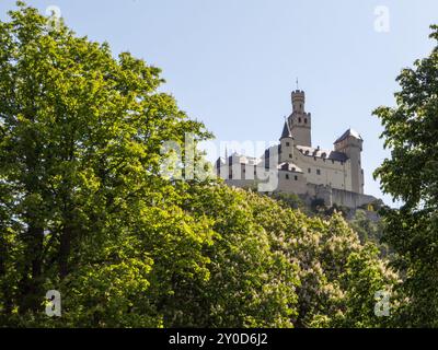 Le majestueux château Marksburg, situé sur le Rhin en Allemagne, se dresse bien en vue sur une colline, ses tours atteignant un ciel bleu clair. L Banque D'Images