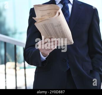 Gros plan des mains de l'homme d'affaires avec un journal sur l'escalier. À l'extérieur Banque D'Images