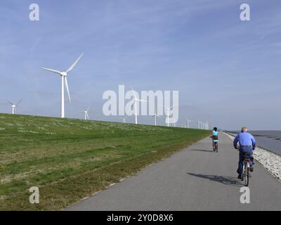 Vélo contre le vent sur une digue près d'Emden Banque D'Images