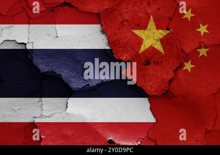 Drapeaux de Thaïlande et de Chine peints sur un mur fissuré Banque D'Images