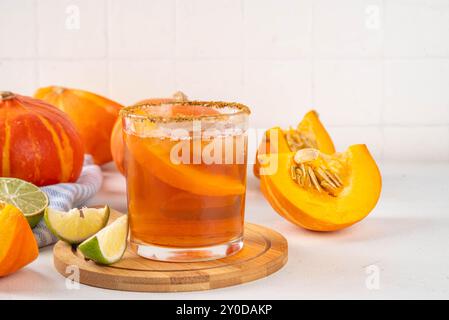 Margarita de Thanksgiving, cocktail d'arbustes de citrouille douce, boisson d'automne savoureuse à l'alcool sur fond blanc avec des tranches de citrouilles, espace de copie Banque D'Images