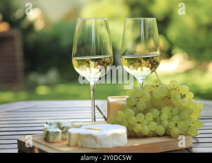 Diverses sortes de fromage, raisins et deux verres de vin blanc Banque D'Images