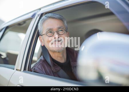 Un homme âgé assis sur le siège du conducteur Banque D'Images