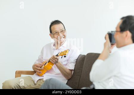 Un vieil homme jouant d'un instrument Banque D'Images