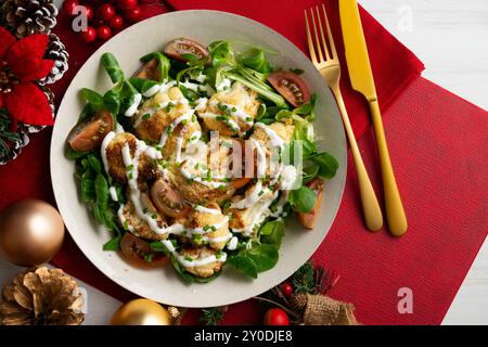 Salade de chou-fleur rôti avec légumes et sauce yaourt. Nourriture sur une table décorée de Noël. Banque D'Images