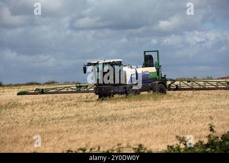 L'agriculteur local pulvérise les récoltes dans cette machine spécialement conçue à cet effet avec des rampes extensibles qui répartissent la pulvérisation en quelques passages pour couvrir l'ensemble du champ. Banque D'Images