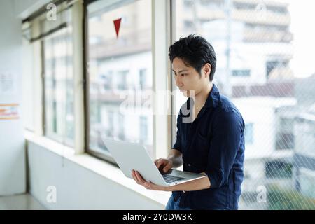 Un homme utilisant l'ordinateur portable Banque D'Images