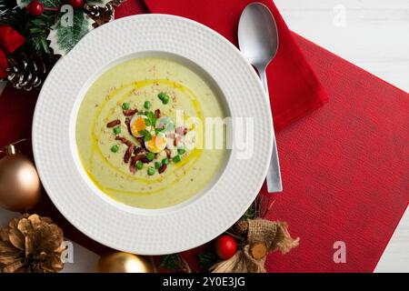 Crème de haricots verts avec jambon ibérique et oeuf de caille. Table vue sur le dessus avec décoration de Noël. Banque D'Images