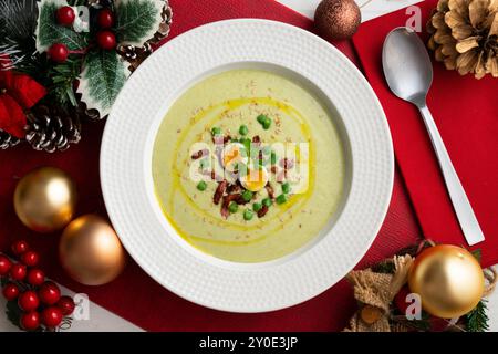 Crème de haricots verts avec jambon ibérique et oeuf de caille. Table vue sur le dessus avec décoration de Noël. Banque D'Images