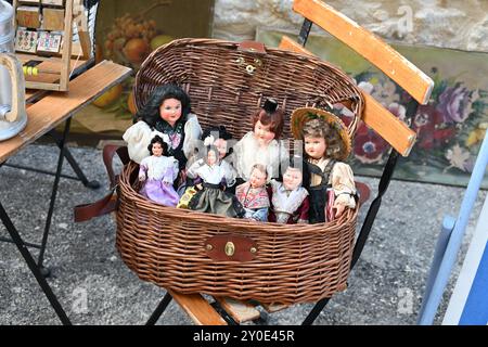 Poupées vintage, à collectionner, à collectionner ou vieilles en costume provençal exposées dans un vieux panier en osier chez Brocante ou Collectors' Market France Banque D'Images