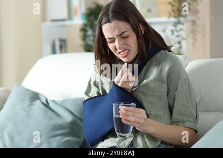 Femme convalescente stressée prenant la pilule analgésique se plaignant à la maison Banque D'Images