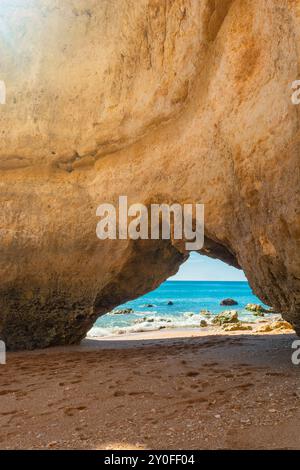 Formation rocheuse de falaise géante avec arc naturel sur la plage de sable près de Portimao dans la région de l'Algarve, Portugal, Europe. Destination touristique populaire pour Banque D'Images