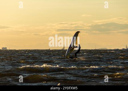 Sandy Hook, New Jersey - 21 août 2024 : les kitesboarders prennent l'eau alors que le soleil se couche sur Sandy Hook par une magnifique nuit d'été Banque D'Images