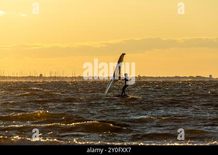 Sandy Hook, New Jersey - 21 août 2024 : les kitesboarders prennent l'eau alors que le soleil se couche sur Sandy Hook par une magnifique nuit d'été Banque D'Images