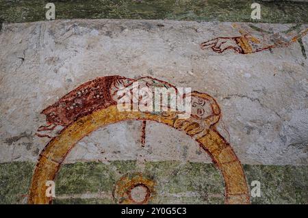 Main de Dieu au-dessus de Sainte Catherine d'Alexandrie alors qu'elle est martyrisée sur la roue (et non triomphante avec la roue détruite comme elle est souvent représentée). Détail de la fresque médiévale dans le cloître de l'Abbazia di Piona (Abbaye de Piona) à Colico, Lombardie, Italie. Banque D'Images