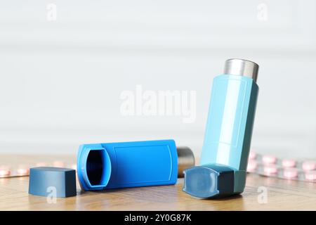 Inhalateurs sur la table en bois à l'intérieur, gros plan avec espace pour le texte. Traitement de l'asthme Banque D'Images