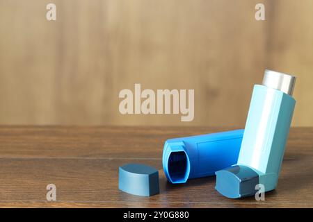 Inhalateurs sur la table en bois à l'intérieur, gros plan avec espace pour le texte. Traitement de l'asthme Banque D'Images