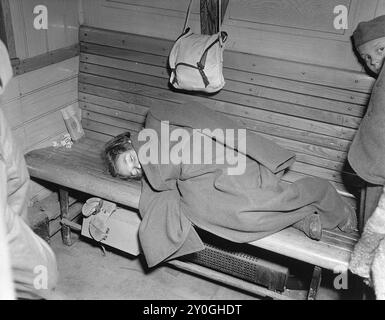 Une petite fille juive fatiguée fait une sieste sur un banc en bois dans le train d’évacuation qui l’emmène, avec d’autres enfants juifs, du camp de concentration de Buchenwald en France. De là, certains seront envoyés en Palestine, d’autres en Amérique Banque D'Images