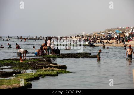 Deir al-Balah, bande de Gaza, Palestine. 20 mai 2024. Les Palestiniens se baignent dans la mer près de Deir al Balah, au centre de la bande de Gaza, qui est en proie à des assauts. Malgré plus de sept mois de violents bombardements israéliens et aucun endroit sûr dans l'enclave palestinienne, les habitants de Gaza visitent le front de mer pour un bref répit après la guerre et la chaleur intense de leurs tentes de fabrication voisines Banque D'Images