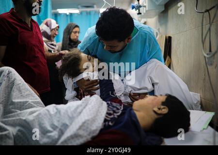 Deir Al-Balah, bande de Gaza, Palestine. 24 octobre 2023. Un garçon palestinien blessé caresse sa sœur sans vie à l’hôpital des martyrs d’Al-Aqsa à Dair Al-Balah, dans le centre de la bande de Gaza. Les blessures et le meurtre par les forces israéliennes d'un grand nombre de Palestiniens, y compris de nombreux enfants, se poursuivent sans relâche pendant leur opération militaire dans l'enclave palestinienne sous blocus en réponse à l'attaque sanglante du Hamas en Israël le 7 octobre Banque D'Images